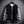 Zwart-grijze varsity jas op hanger, moderne streetwear stijl, met geribbelde boorden en knoopsluiting, tegen een metalen raster achtergrond.