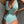 Groen-wit gestreept badpak, vrouw, strandmode, zomerstijl, elegante strandkleding, trendy badmode, zonneklep, modieuze oorbellen.