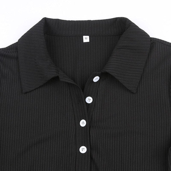Zwarte ribgebreide blouse met knoopsluiting en kraag, maat M. Stijlvolle damesmode, geschikt voor casual en zakelijke outfits.
