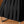 Zwarte geplooide rok op metalen kledingrek, elegante damesmode, stijlvolle kleding, tijdloze zwarte rok, modetrends, kledingwinkel display.