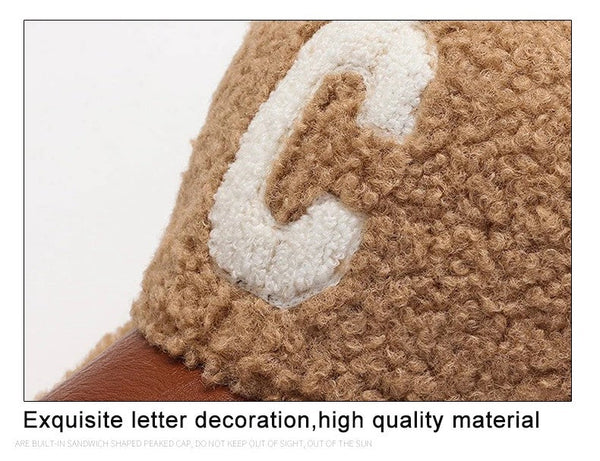 Bruine wollen pet met witte geborduurde letter "C", hoogwaardige materialen, stijlvolle accessoire, perfect voor modieuze casual outfits.