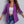 Vrouw in paarse blazer, witte crop top en blauwe jeans tegen grijze achtergrond. Modieuze dameskleding, trendy outfit, casual stijl.