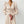 Elegante vrouw in crèmekleurige jurk met lange mouwen en knoopdetails, minimalistische mode, stijlvolle dameskleding, moderne outfit.