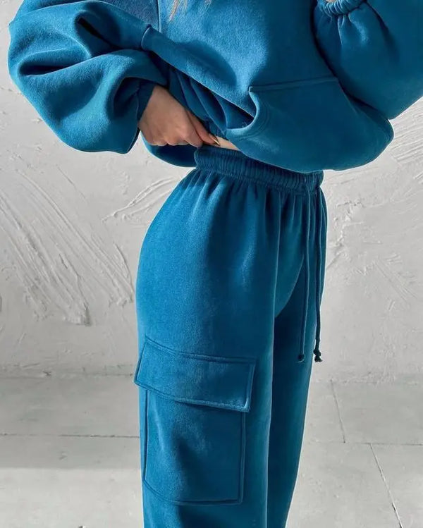 Blauwe fleece trainingspak dames, comfortabele joggingbroek met zakken en elastische tailleband, trendy sportkleding voor casual en actieve stijl.
