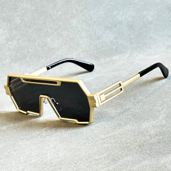 Gouden futuristische zonnebril met zwarte glazen en geometrisch ontwerp op grijze achtergrond. Trendy unisex accessoire, modieuze zonnebrillen.