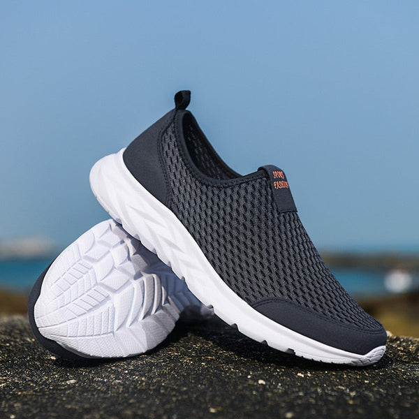 Donkergrijze ademende sneakers met witte zool, perfect voor hardlopen en wandelen. Lichtgewicht sportschoenen voor heren, ideaal voor dagelijks gebruik.