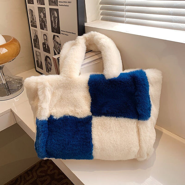 Pluche handtas met blauw-witte blokken, trendy en stijlvol, perfect voor wintermode. Ideaal accessoire voor dames, zachte en modieuze uitstraling.