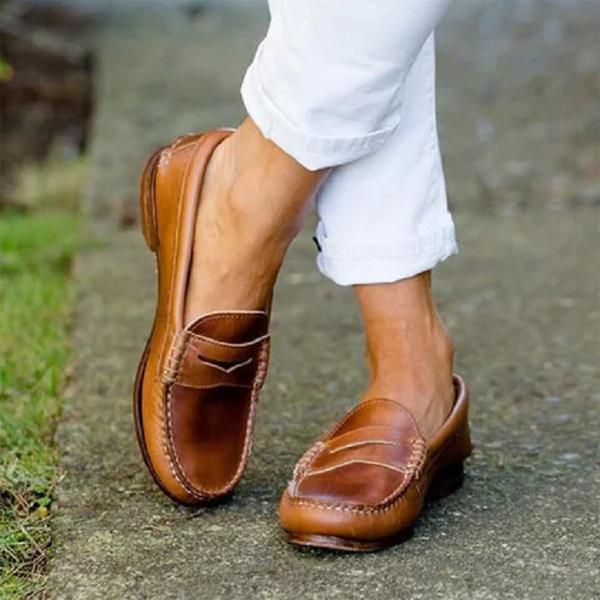 Bruine leren loafers voor heren, gedragen met witte broek, op stoep. Stijlvolle casual schoenen, perfect voor dagelijks gebruik en comfort.