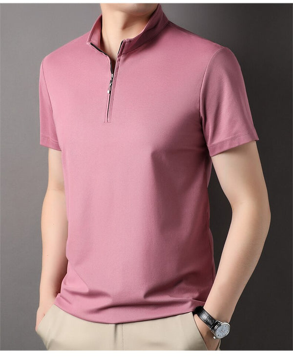 Man in roze polo met rits, korte mouwen, casual stijl, grijze achtergrond. Perfect voor zomermode, herenmode, trendy kleding.