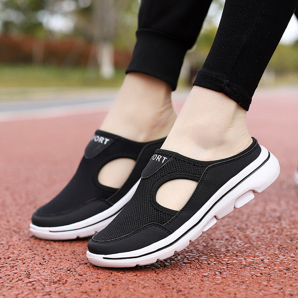 Zwarte sportieve instappers met ademend mesh en witte zool, ideaal voor wandelen en casual gebruik. Comfortabele en modieuze damesschoenen.