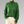 Groene gebreide trui met kabelpatroon, hoge kraag en lange mouwen, gedragen door model. Perfect voor herfst- en wintermode.