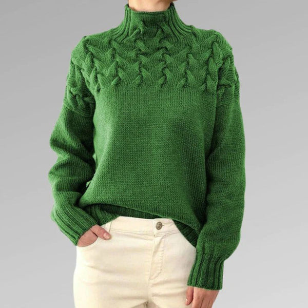 Groene gebreide trui met kabelpatroon, hoge kraag en lange mouwen, gedragen door model. Perfect voor herfst- en wintermode.