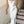 Vrouw in elegante witte satijnen jurk op marmeren trap, avondkleding, mode, glamour, stijlvolle outfit, luxe uitstraling.