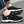 Zwarte sportieve herenschoenen met witte zool, slip-on design, merklogo, geschikt voor casual en outdoor activiteiten. Comfortabele en modieuze sneakers.