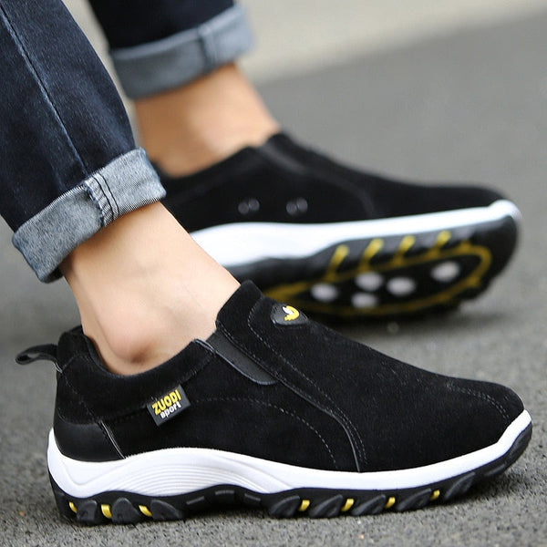 Zwarte sportieve herenschoenen met witte zool, slip-on design, merklogo, geschikt voor casual en outdoor activiteiten. Comfortabele en modieuze sneakers.