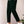 Modieuze groene herenbroek, gecombineerd met witte sneakers en een casual wit T-shirt. Perfect voor een stijlvolle, eigentijdse look.