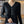 Vrouw in zwarte V-hals trui met knopen, zilveren ketting en ring. Stijlvolle damesmode, herfstkleding, casual chic outfit.