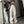 Vrouw in trendy sportieve outfit met beige wijde broek en zwart T-shirt, poseert voor spiegel. Streetwear mode, casual stijl, moderne kleding.