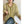 Vrouw draagt gestreepte groene en witte hoodie met rits, zittend aan tafel. Modieuze casual dameskleding, comfortabele herfstoutfit.