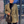 Vrouw met groene blazer en zwarte handtas voor verlichte achtergrond, stijlvolle mode, moderne outfit, avondlook.
