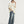 Jonge man in oversized beige T-shirt en wijde jeans, draagt een beige pet en sneakers. Casual streetwear mode, trendy outfit voor jongeren.