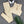 Beige naadloze sportset met top en legging, witte koptelefoon en groene palmbladaccessoire op grijze achtergrond. Perfect voor yoga en fitness.