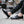 Zwarte leren loafers voor heren met witte en rode zool, gedragen met opgerolde jeans. Stijlvolle casual schoenen voor dagelijks gebruik.