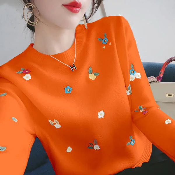 Oranje trui met kleurrijke bloemenborduursels, gedragen door vrouw. Trendy damesmode, herfstkleding, stijlvolle gebreide trui, casual outfit.