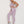 Vrouw in lila sportset, bestaande uit een crop top en leggings, poseert tegen een witte achtergrond. Dames sportkleding, fitnessmode, actieve stijl.