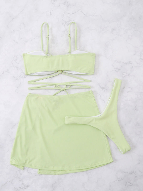 Lichtgroene bikini set met top, rok en string op marmeren achtergrond. Perfecte strandkleding, trendy badmode, zomeroutfit voor dames.
