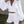 Vrouw in witte zomerset met pofmouwen en korte broek, strandtas in hand. Perfect voor zomermode, casual en elegante stijl.