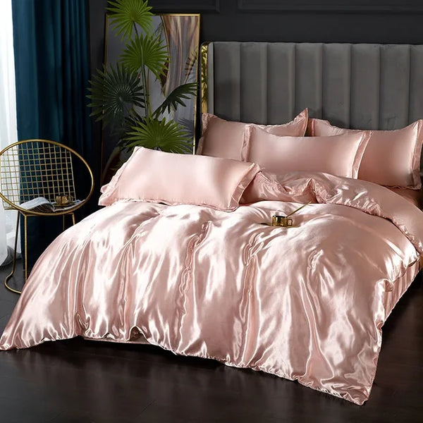 Luxe zijden dekbedovertrek in zachtroze op een kingsize bed, met bijpassende kussens, gouden decoratieve stoel en groene planten in een moderne slaapkamer.