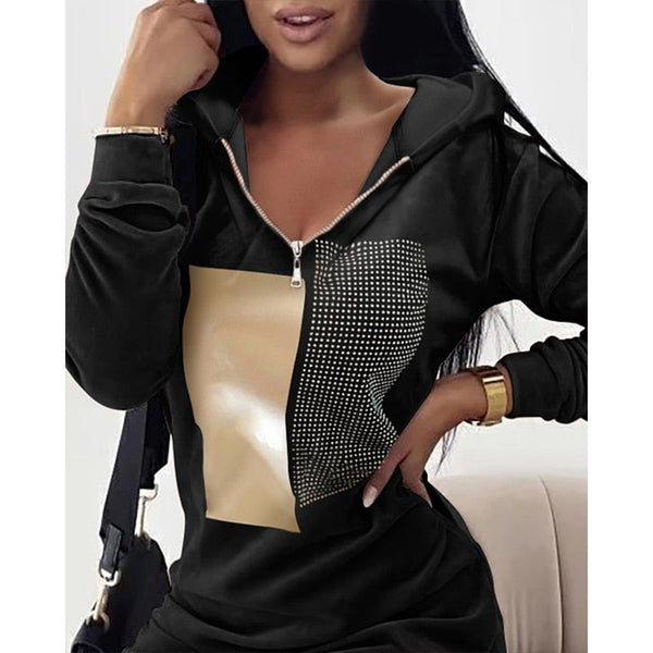 Zwarte dameshoodie met goudkleurig en gestippeld design, ritssluiting en lange mouwen. Modieuze casual kleding voor dames.