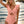Vrouw in roze badpak met ruches, strand op achtergrond, zomermode, strandkleding, trendy badmode, zonsondergang, zeezicht.