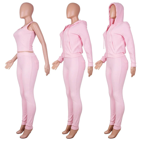 Roze dames trainingspak met capuchon, bestaande uit een crop top en joggingbroek. Perfect voor sport en casual mode. Comfortabel en stijlvol ontwerp.