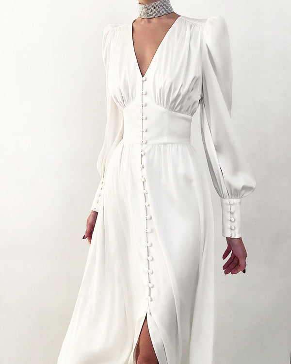 Elegante witte jurk met lange mouwen, knoopsluiting en diepe V-hals. Perfect voor bruiloften en formele gelegenheden. Tijdloze mode.