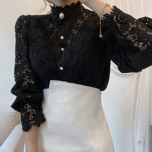Zwarte kanten blouse met parelknopen en hoge kraag, gecombineerd met een witte rok. Elegante damesmode, geschikt voor formele gelegenheden.