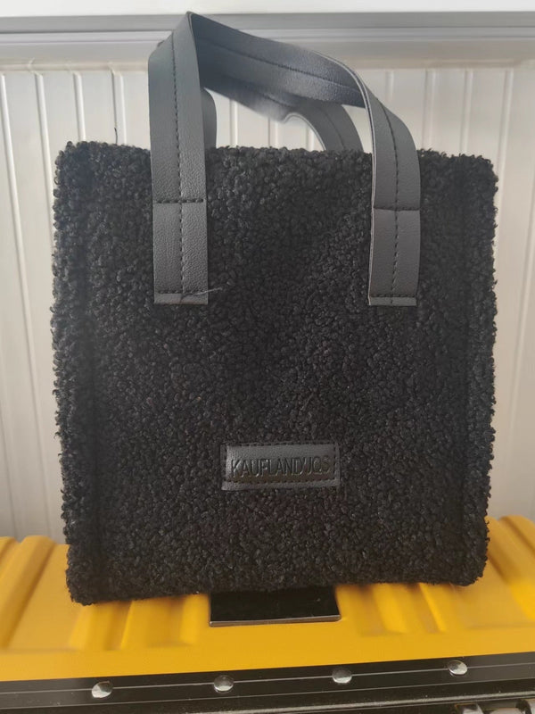 Zwarte schoudertas van bouclé stof met leren handvatten, merklogo "KAUFLANDJOS", stijlvolle en trendy accessoire voor dagelijks gebruik.