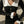 Vrouw in zwarte geribbelde jurk met witte kraag en knopen, houdt een zwarte handtas vast. Elegante mode, herfstkleding, straatstijl.