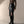Vrouw in stijlvolle outfit met zwarte leren rok met split, bruine top en hoge laarzen. Modieuze dameskleding, herfstmode, elegant design.