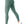 Groene, geribbelde sportlegging voor dames, hoge taille, naadloos ontwerp, gecombineerd met witte sneakers. Perfect voor fitness en yoga.