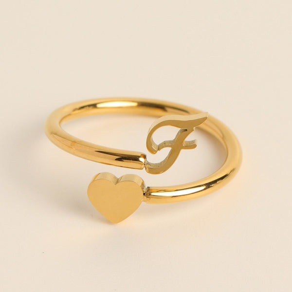 Gouden ring met hart en letter F, minimalistisch design, gepolijst, perfect als cadeau, sieraden voor dames, elegante en moderne stijl.