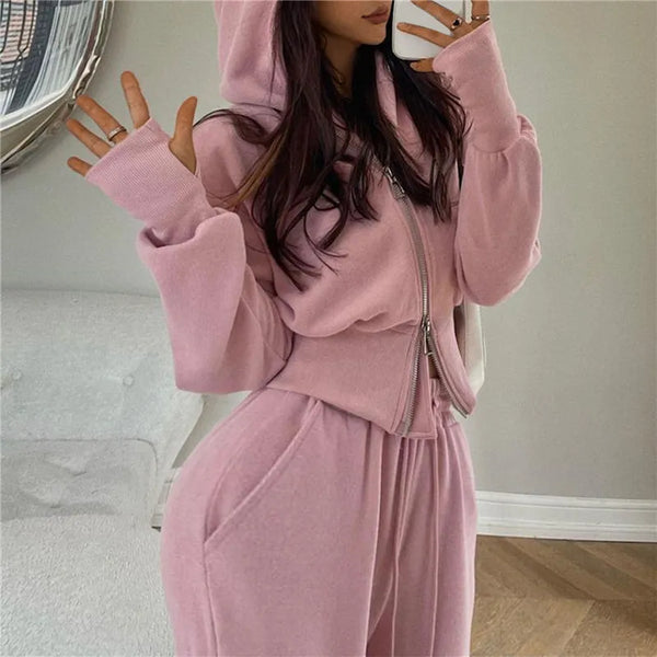 Vrouw in roze joggingpak met capuchon, comfortabele loungewear, trendy mode, casual outfit, zachte stof, moderne kledingstijl, binnenhuis.