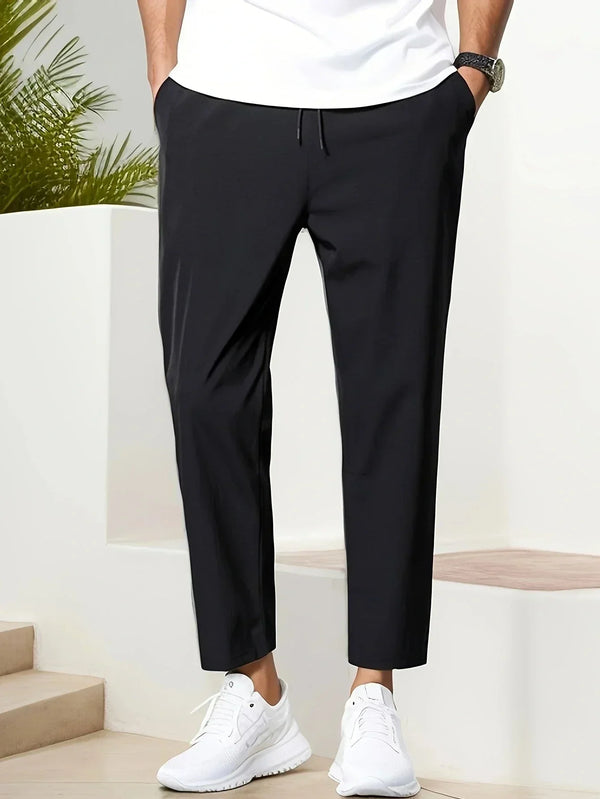 Zwarte herenbroek, casual stijl, gedragen met witte sneakers en wit T-shirt. Perfect voor moderne, comfortabele mode. Geschikt voor dagelijks gebruik.