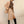 Elegante vrouw in beige blazer en rok met bruine stippenblouse, zwarte laarzen en zonnebril. Modieuze dameskleding, herfststijl.