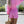 Vrouw in roze zomeroutfit met pofmouwen en korte broek, draagt een strooien tas. Perfecte zomermode, casual en stijlvol voor zonnige dagen.
