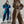 Twee vrouwen in comfortabele joggingpakken; links in blauw met sneakers, rechts in bruin met capuchon. Modieuze loungewear, casual stijl.