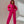 Vrouw in felroze joggingpak met capuchon, poseert tegen een neutrale achtergrond. Modieuze dameskleding, comfortabele streetwear, trendy outfit.