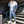 Man in blauw-wit trainingspak met capuchon en sneakers op zwarte trap. Stijlvolle sportkleding, casual outfit, moderne herenkleding.