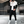 Moderne man in zwart-wit trainingspak met sneakers in minimalistische kledingwinkel. Stijlvolle sportkleding, urban fashion, herenkleding.